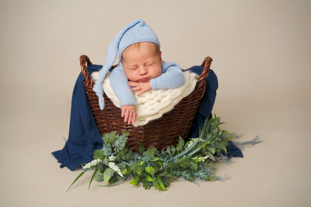 Neugeborenen Fotoshooting, Newborn Fotoshootings, Baby in Holzkorb, Kopf auf Hand gestützt, Babyfotografie Ingolstadt Mandy Limbach