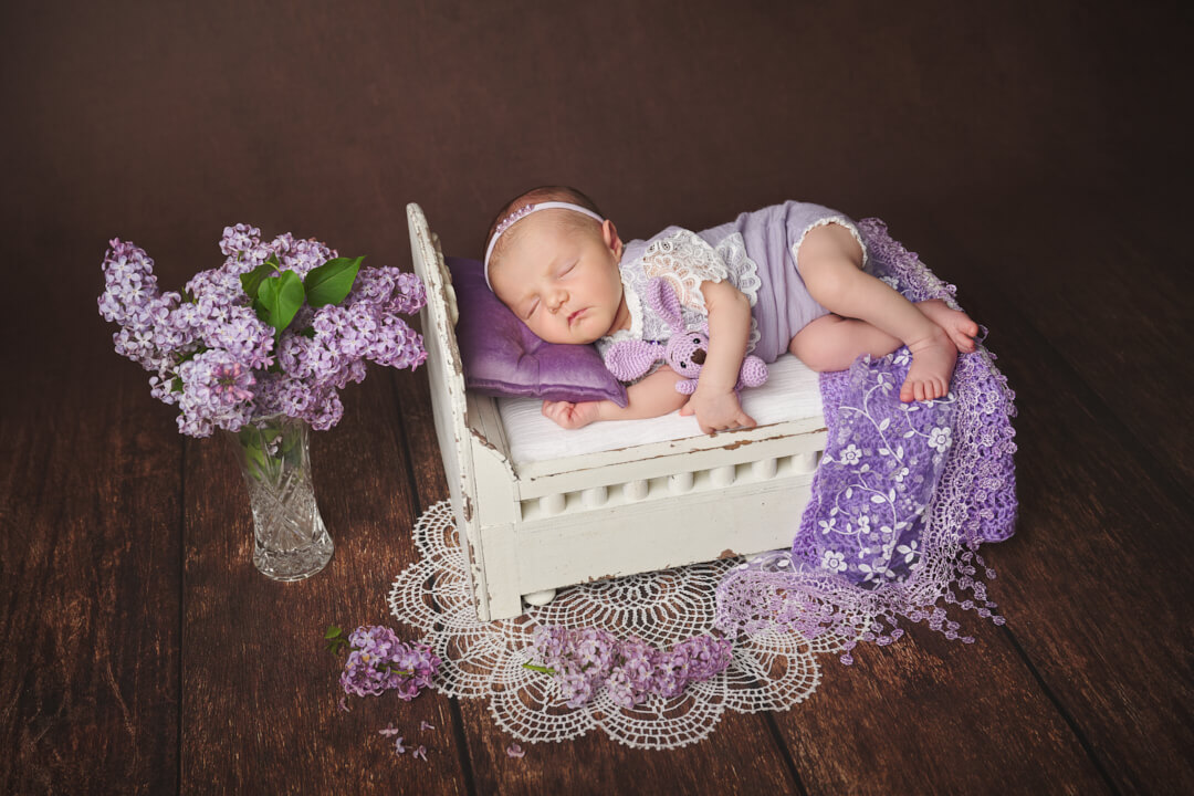 Neugeborenen Fotoshooting, Baby auf Vintage Holzbett liegend in Kulisse fliederfarben Babyfotografie Ingolstadt Mandy Limbach Fotografie